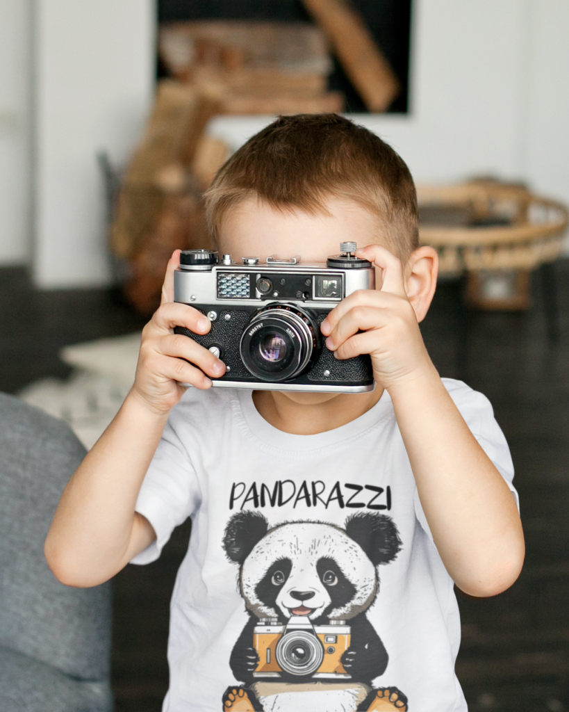 Kid with camera wearing t-shirt with a Panda holding camera and the text Pandarazzi