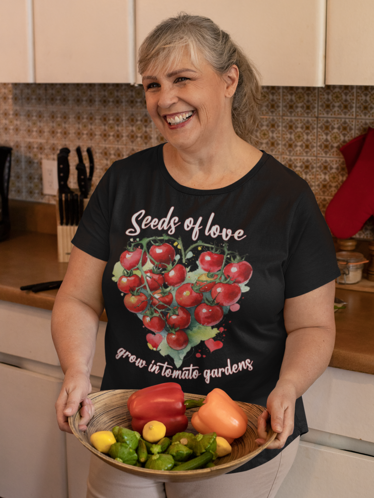 Woman wearing t-shirt with tomatoes in shape of heart and text - Seeds of Love grow in tomato gardens