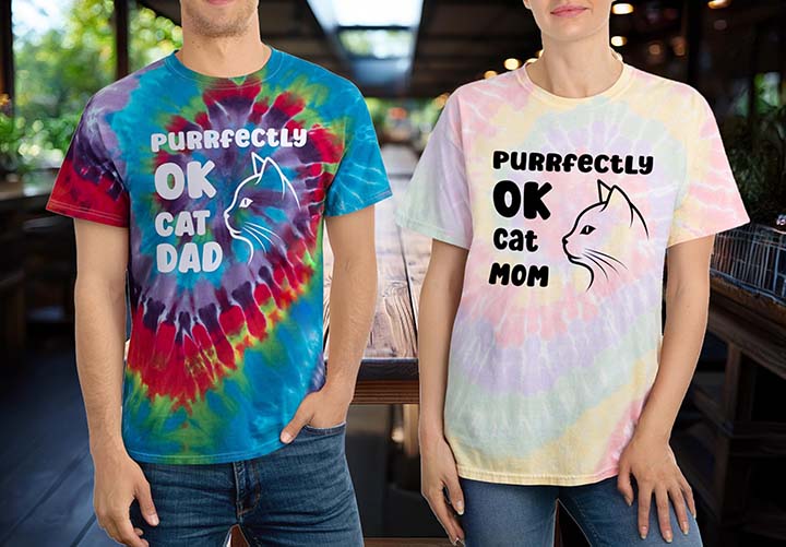 Man and Woman wearing tye dye shirts with text Purrfectly OK